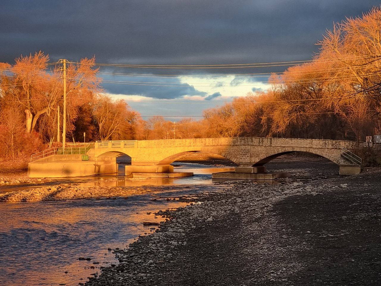 Stone bridge and river illuminated by sunset in Eastern Canada