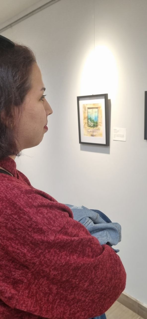 Zahra Zandiyeh viewing watercolor work at Kitchener Library Art Exhibition