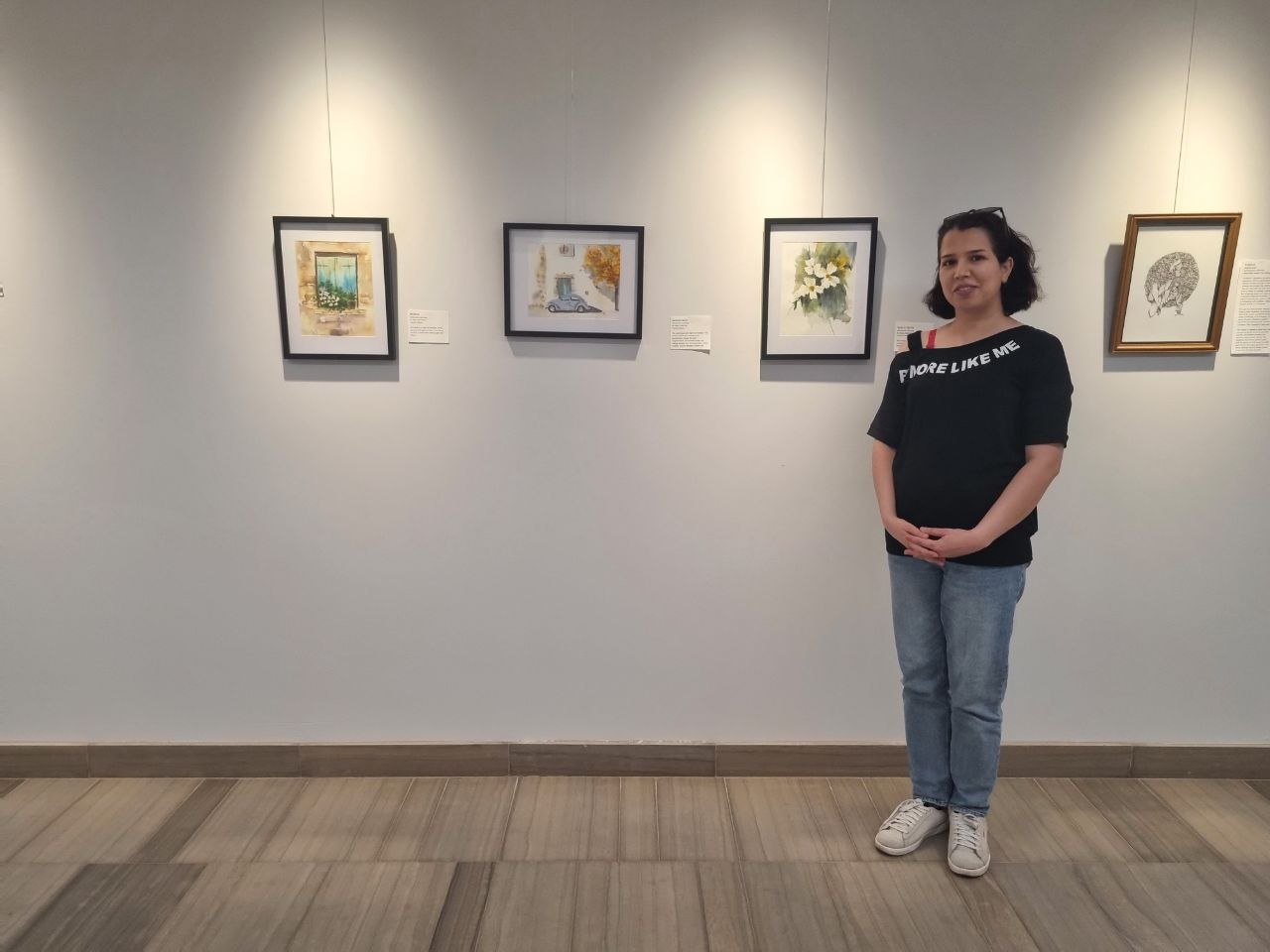 Zahra Zandiyeh with her watercolor paintings at an art exhibition